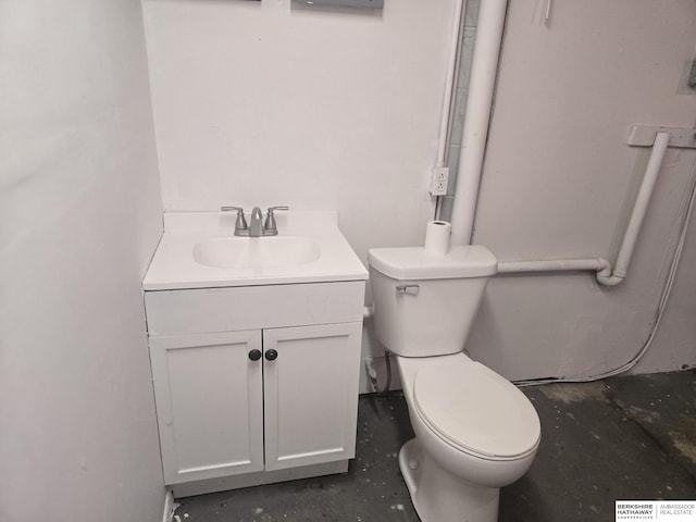 bathroom with vanity, concrete flooring, and toilet