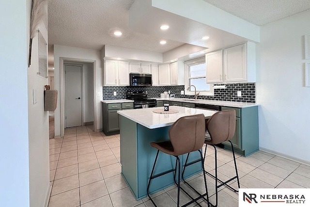 kitchen featuring electric range, a kitchen breakfast bar, a center island, and white cabinets