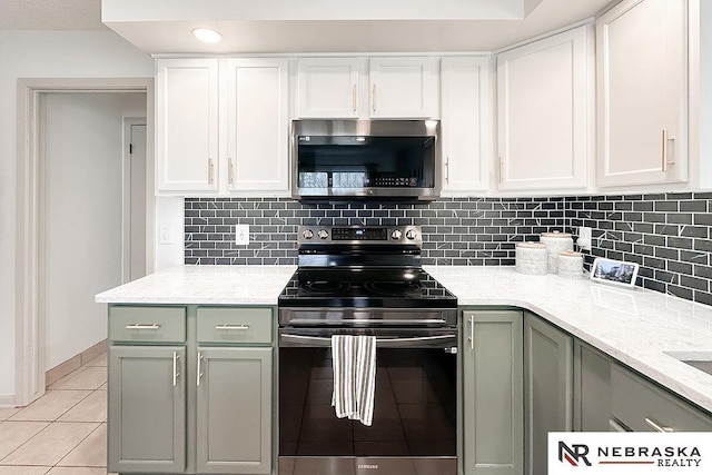 kitchen with light tile patterned floors, decorative backsplash, stainless steel appliances, and white cabinets