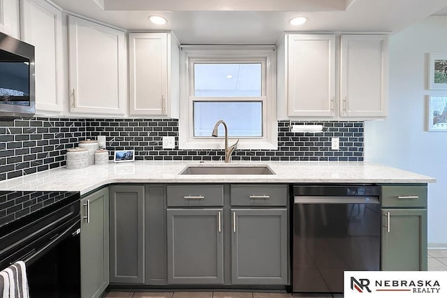 kitchen with sink, appliances with stainless steel finishes, backsplash, light stone counters, and white cabinets