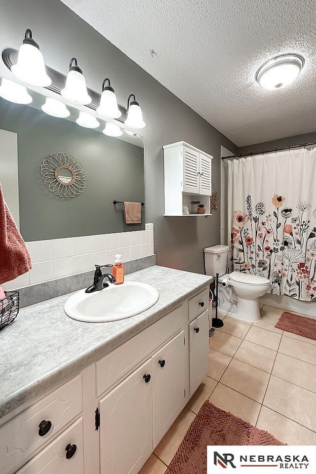 bathroom featuring vanity, a textured ceiling, curtained shower, tile patterned floors, and toilet