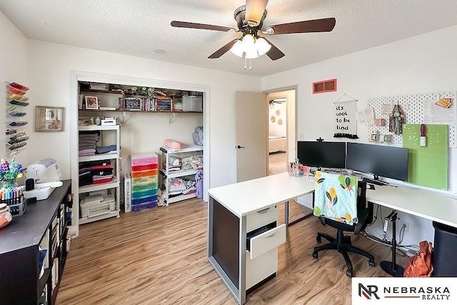 office area with ceiling fan, a textured ceiling, and light wood-type flooring