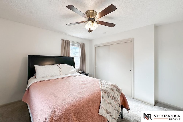 carpeted bedroom with ceiling fan, a closet, and a textured ceiling