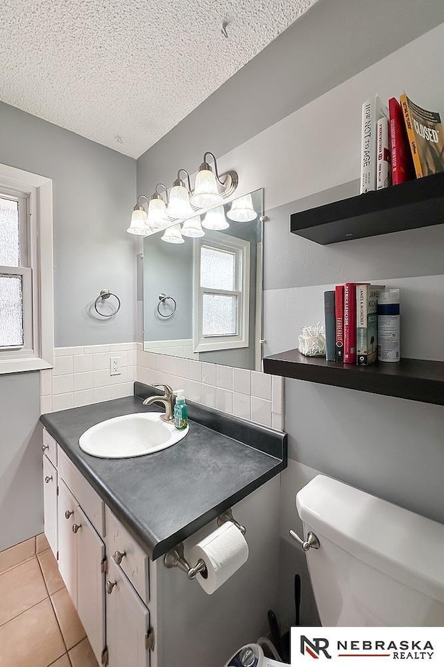 bathroom featuring tile patterned flooring, a textured ceiling, tasteful backsplash, and toilet