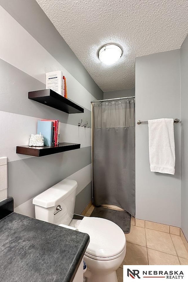 bathroom featuring vanity, toilet, tile patterned floors, a textured ceiling, and a shower with shower curtain