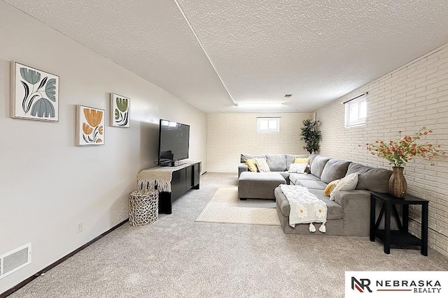 living room with a textured ceiling and brick wall