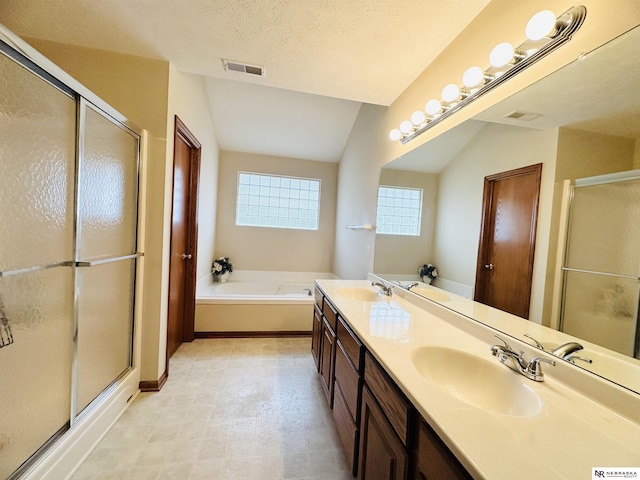 bathroom featuring plus walk in shower, vaulted ceiling, and a textured ceiling