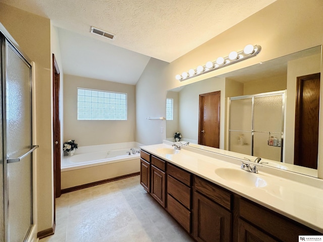 bathroom with vanity, shower with separate bathtub, vaulted ceiling, and a textured ceiling