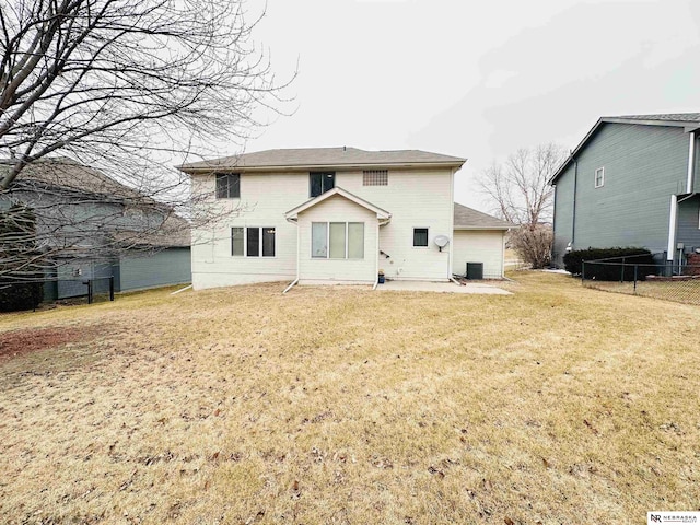 rear view of house with central AC unit and a yard