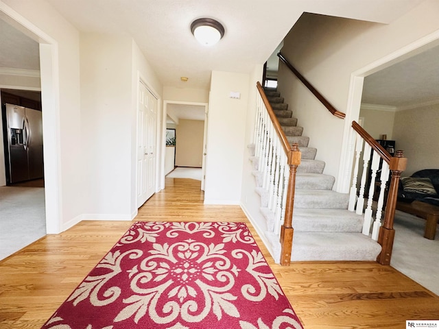 foyer entrance featuring wood-type flooring and ornamental molding