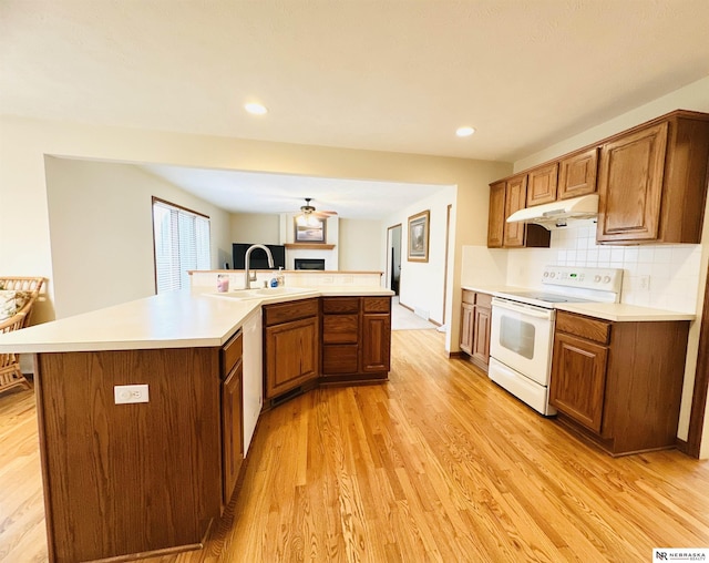 kitchen featuring tasteful backsplash, a large island, white appliances, and light hardwood / wood-style floors