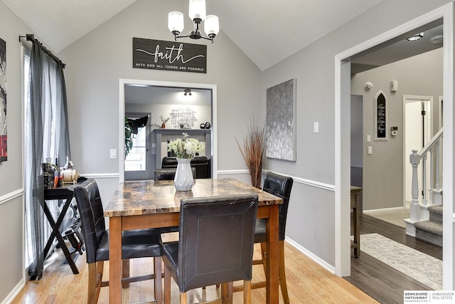 dining area with vaulted ceiling, light hardwood / wood-style floors, and a notable chandelier