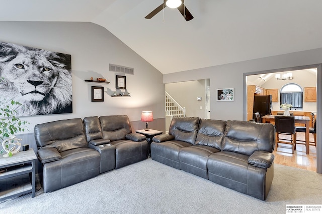 living room with ceiling fan with notable chandelier, vaulted ceiling, and hardwood / wood-style flooring