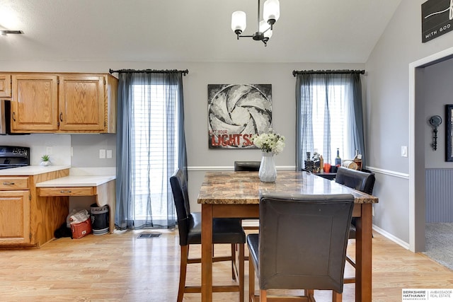 dining area featuring light wood-type flooring and an inviting chandelier