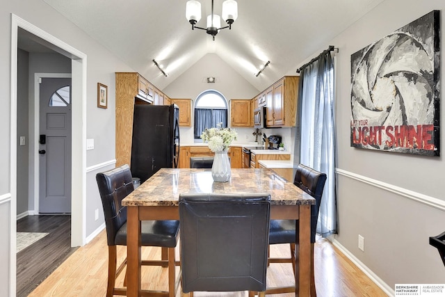 dining room featuring lofted ceiling and light hardwood / wood-style flooring