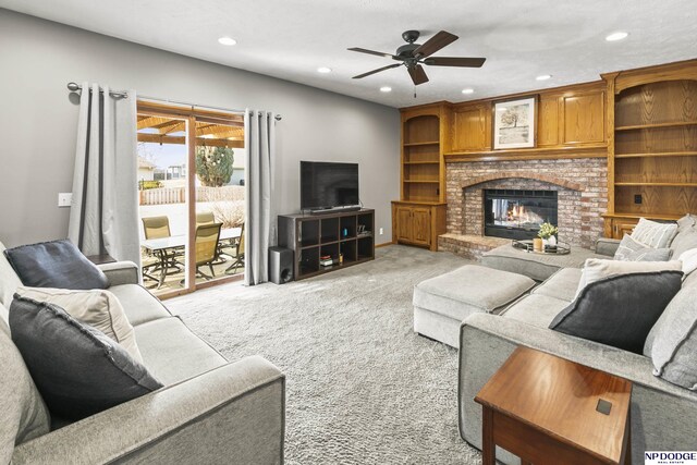 carpeted living room featuring ceiling fan and a brick fireplace