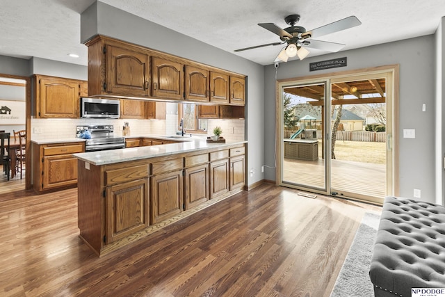 kitchen featuring stainless steel appliances, dark hardwood / wood-style flooring, sink, and backsplash