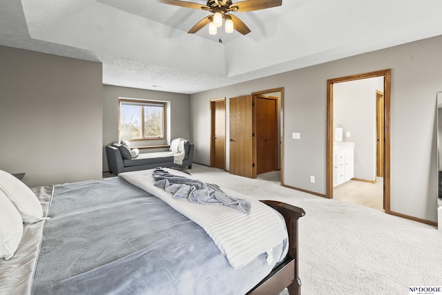 carpeted bedroom with a tray ceiling and ceiling fan