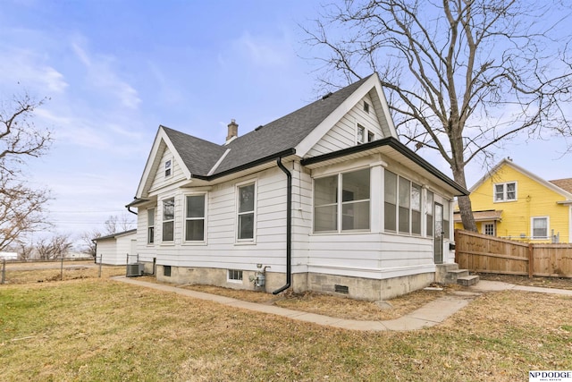 view of home's exterior with cooling unit, a yard, and a sunroom