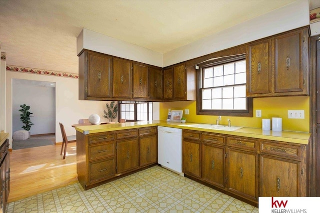 kitchen featuring dishwasher, sink, and kitchen peninsula