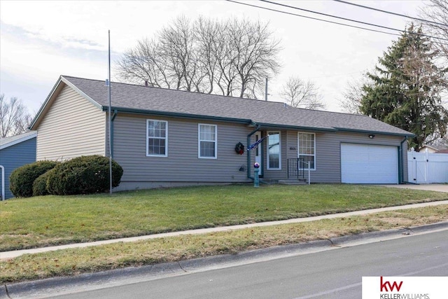 ranch-style house with a garage and a front lawn