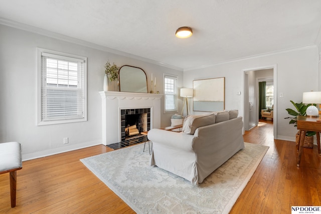 living room with hardwood / wood-style flooring, a fireplace, and ornamental molding