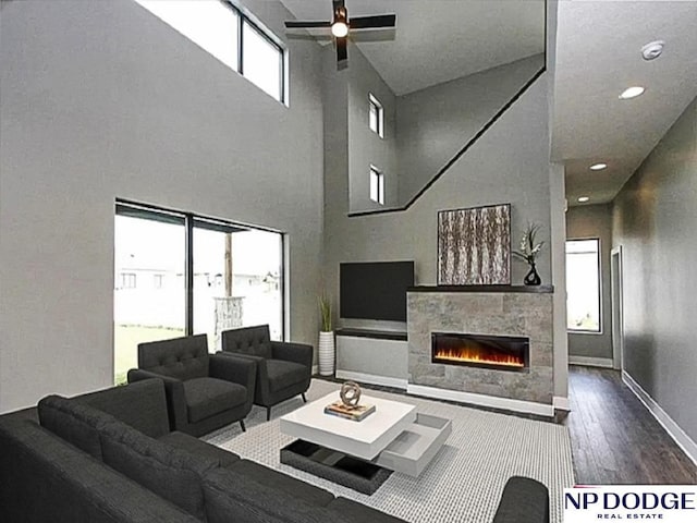 living room featuring ceiling fan, hardwood / wood-style floors, and a high ceiling