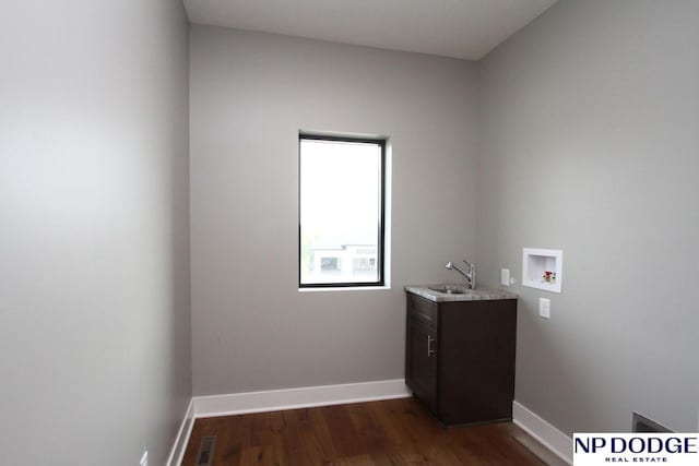 washroom with cabinets, sink, dark hardwood / wood-style flooring, and hookup for a washing machine