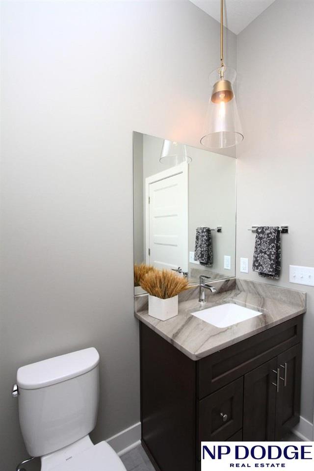 bathroom featuring vanity, vaulted ceiling, and toilet