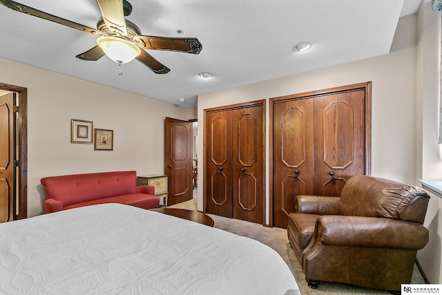 bedroom featuring multiple closets, carpet flooring, and ceiling fan