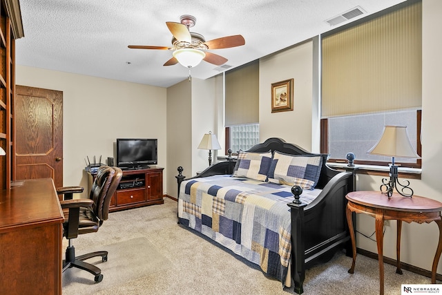 carpeted bedroom featuring ceiling fan and a textured ceiling