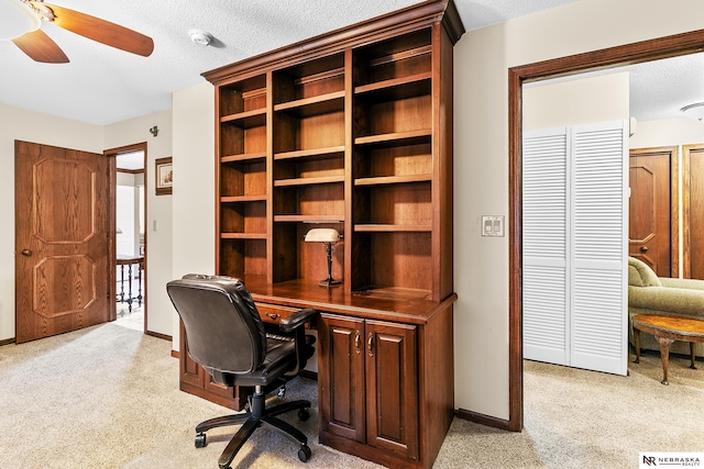 carpeted office with ceiling fan and a textured ceiling