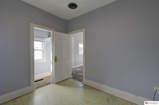 unfurnished room with visible vents, baseboards, and tile patterned floors