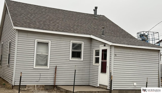 rear view of property with a shingled roof