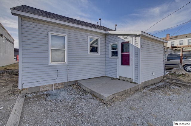 back of house with a patio and a shingled roof