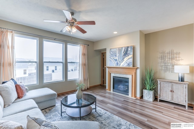 living room featuring a textured ceiling, light hardwood / wood-style flooring, and ceiling fan