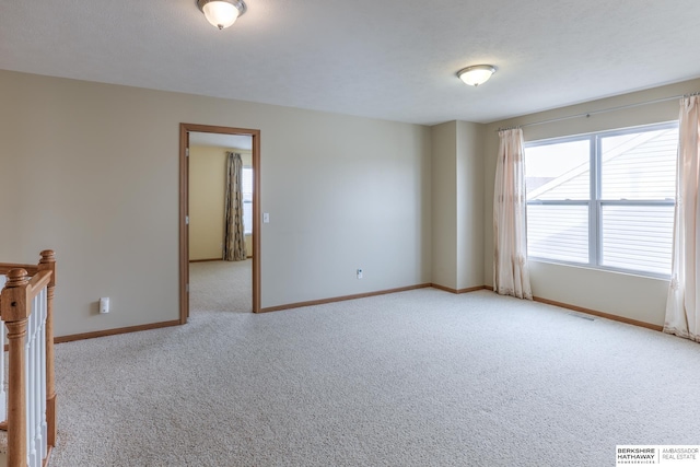 unfurnished room featuring light carpet