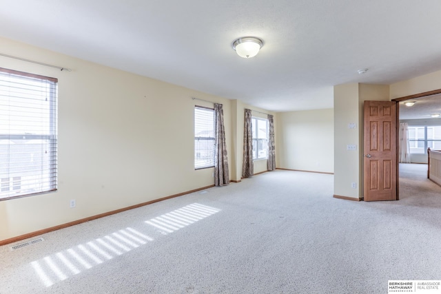 unfurnished room with light carpet and plenty of natural light