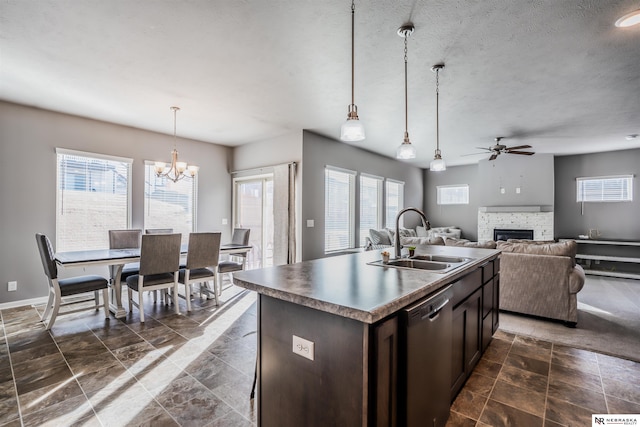 kitchen with sink, hanging light fixtures, dark brown cabinetry, an island with sink, and stainless steel dishwasher