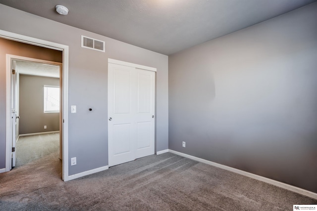 unfurnished bedroom with carpet floors and a closet