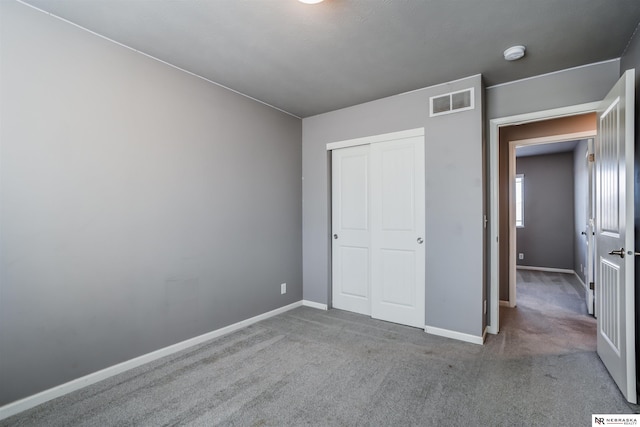 unfurnished bedroom with carpet flooring and a closet