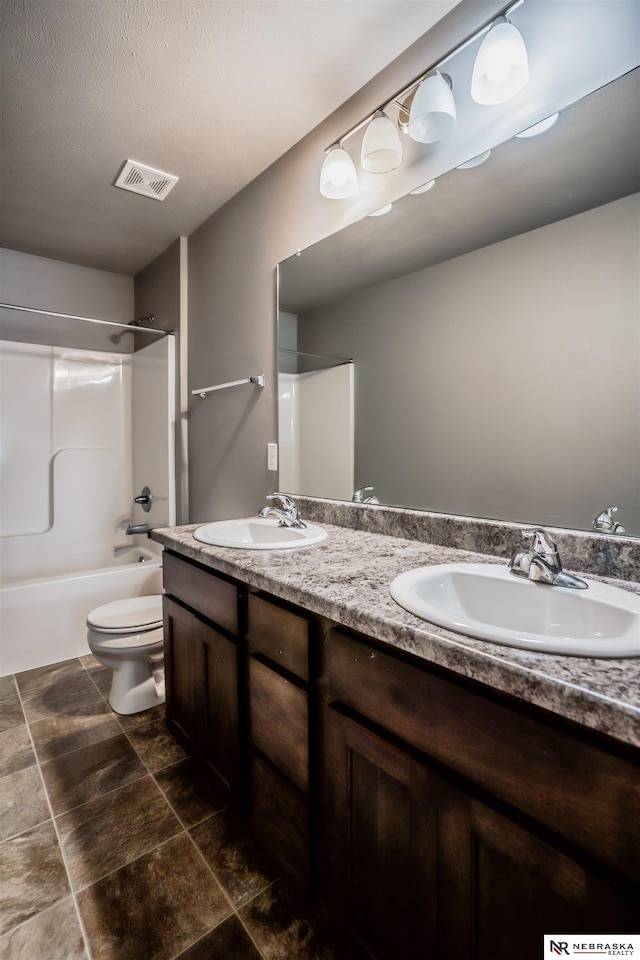 full bathroom featuring washtub / shower combination, vanity, and toilet