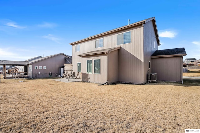 back of house with a lawn and a patio