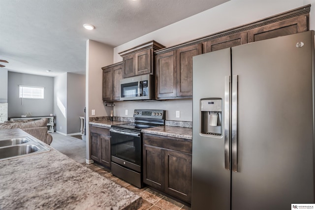 kitchen with sink, ceiling fan, stainless steel appliances, dark brown cabinets, and a textured ceiling