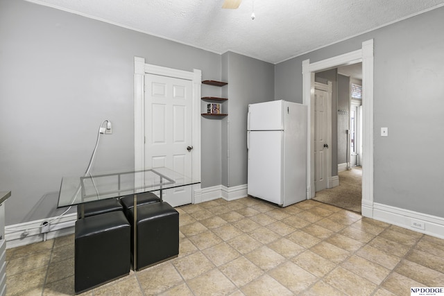 interior space featuring white refrigerator, ceiling fan, and a textured ceiling