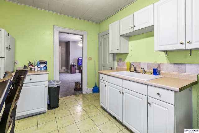 kitchen with white cabinetry, sink, and light tile patterned floors