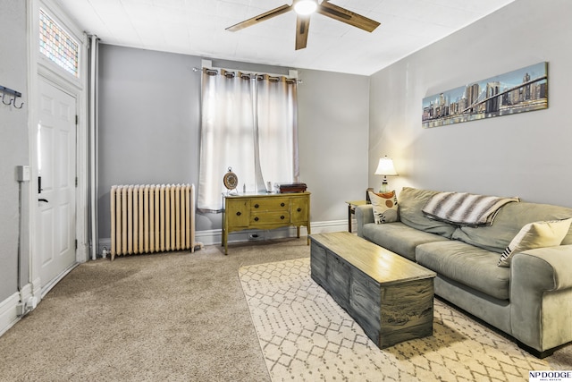 carpeted living room featuring radiator heating unit, ceiling fan, and plenty of natural light