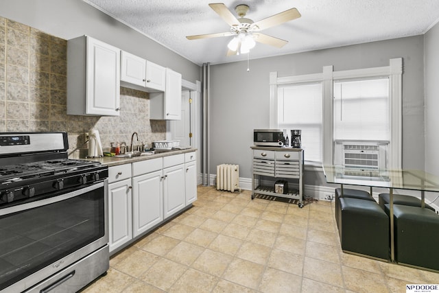 kitchen with white cabinets, appliances with stainless steel finishes, sink, and radiator heating unit