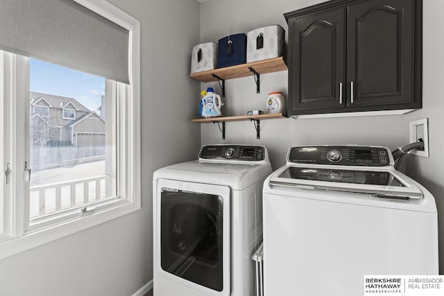 clothes washing area featuring cabinets and washing machine and dryer