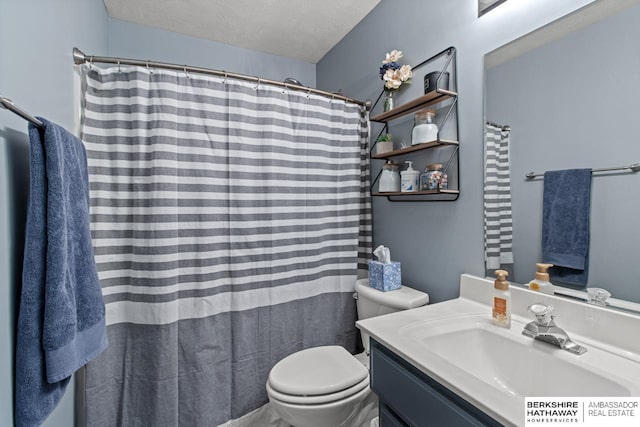 bathroom with vanity, a textured ceiling, and toilet